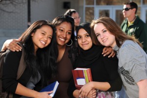 Group of diverse students in a group with others in the background
